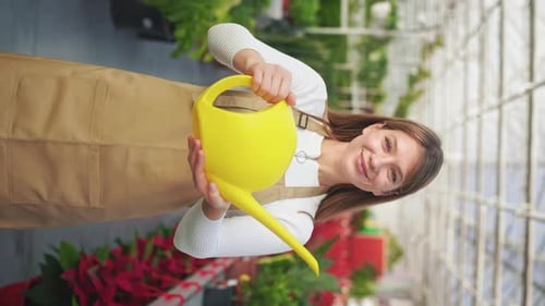 Woman Holding Watering Can in Greenhouse