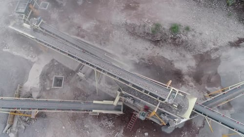 Industrial machine pulverizing rock into different types of gravel and sand in a quarry - Aerial vie