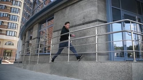 Young man running and jumping above obstacle in the city at daytime