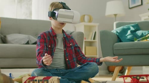 Blond Boy Immersed in Virtual Reality at Home