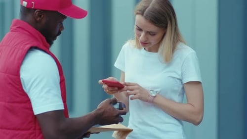 Close Up American Delivery Man Hold Package Woman Client Paying By Contactless Terminal for Parcel