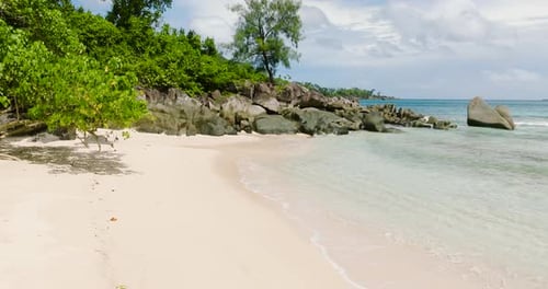 Sandstrand mit Granitfelsen und viel Grün Seychellen Mahe