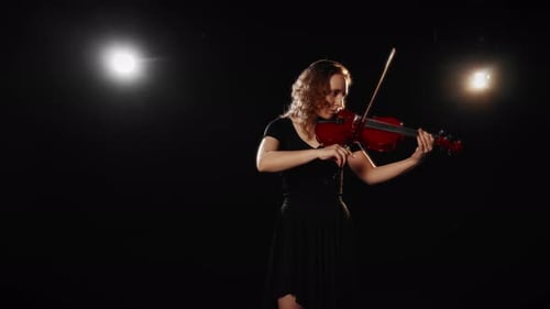 Woman Playing Violin Under Stage Lights