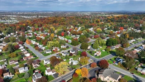 American suburb neighborhood with colorful autumn trees. High aerial shot of houses.