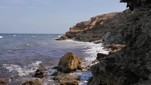 Sea Waves Break on the Coastal Rocks