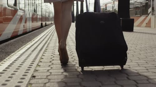 Confident Woman With Luggage Walking on Railway Station