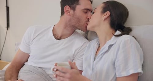 Intimate Couple Kissing in Bed Together