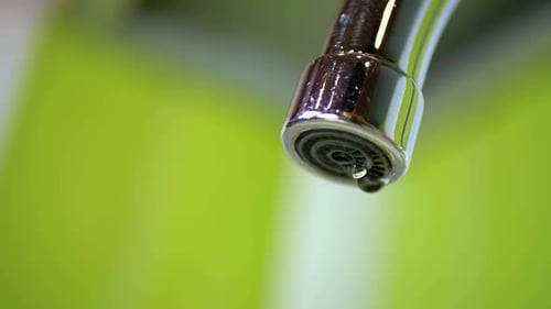 Water Dripping From the Tap Into a Sink Slow Motion