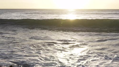 Slowmotion close up of a wave breaking towards rocks at sunset in Hawaii