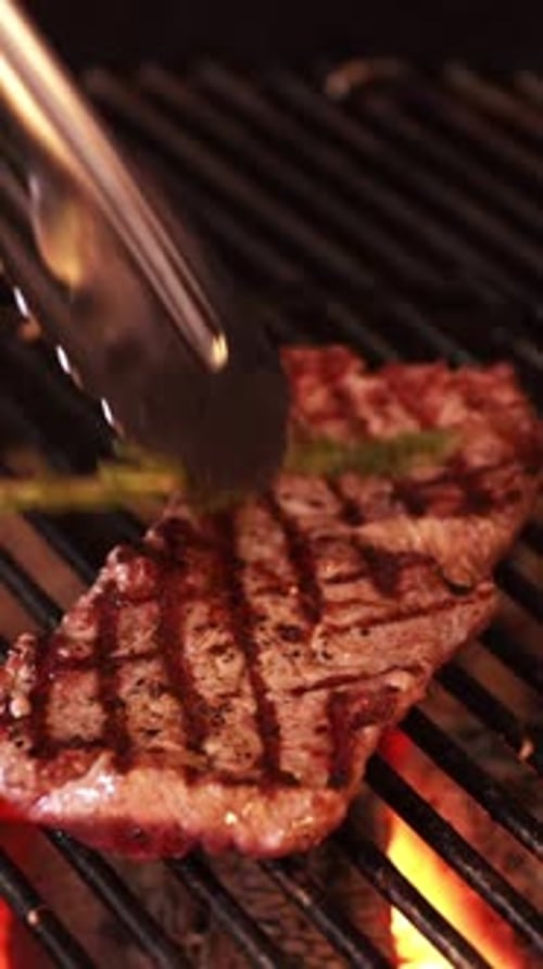 Grilled Steaks with Rosemary on a Sizzling Grill