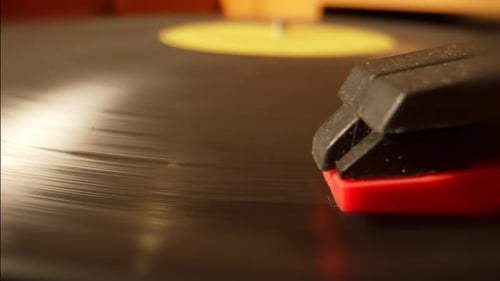 A close-up shows a vintage record player needle moving on spinning vinyl, a nostalgic and warm music