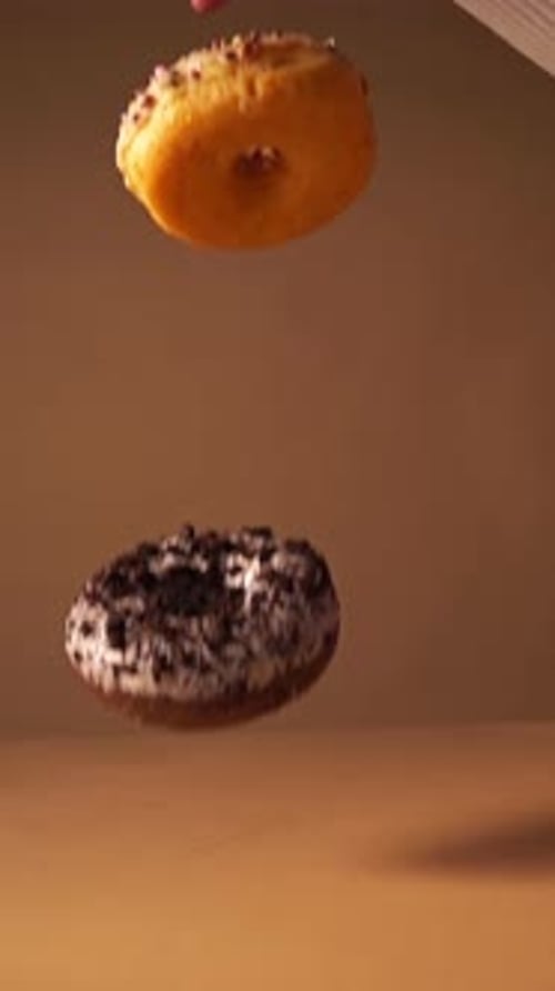Slow Motion Donuts Falling with Cookie Crumbs and Candy Pieces