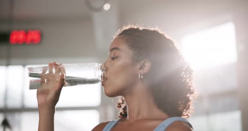 Woman, drinking water and health in gym with fitness for exercise break