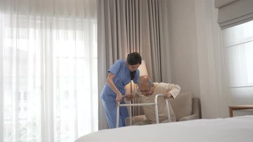 Senior Man Walking with Assistance in Bright Room