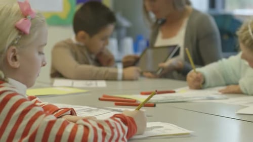Teacher assisting students with work in classroom