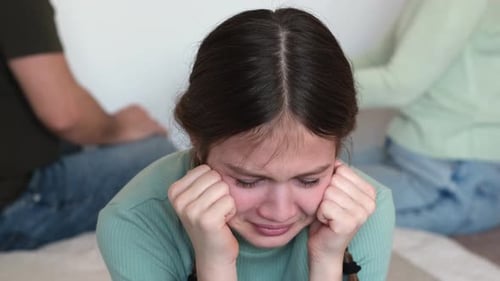 Distraught Teen Crying with Parents Nearby