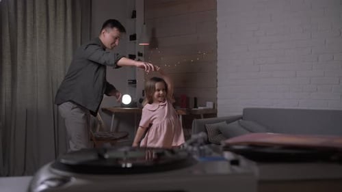 Father and Daughter Dancing Together in Home