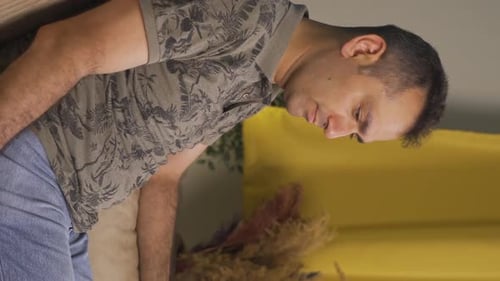 Man Sitting on Couch, Opens Medicine Bottle