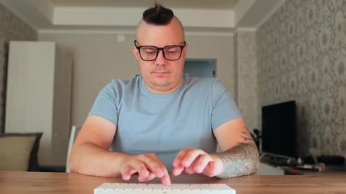 Focused Man Typing on Keyboard at Desk