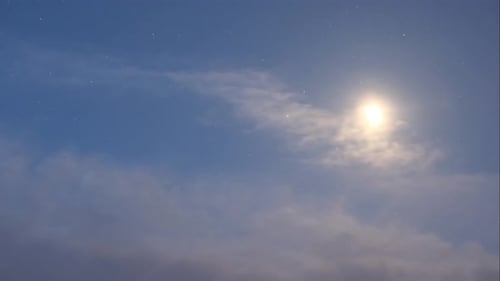 Bright Light Emerging from Cloudy Night Sky