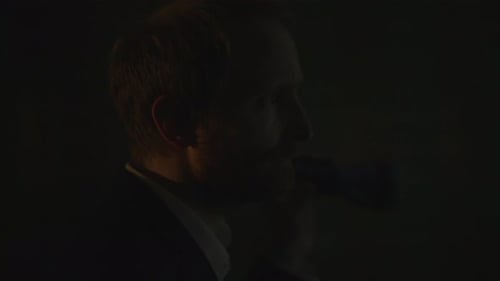 Man Holding Flashlight Investigating Dark Urban Location at Night