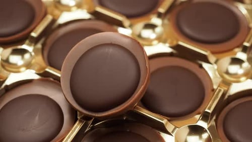 Chocolate Candies Rotate on an Orange Background
