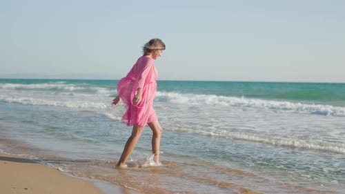 Woman in a Dress Fun on the Sandy Seashore