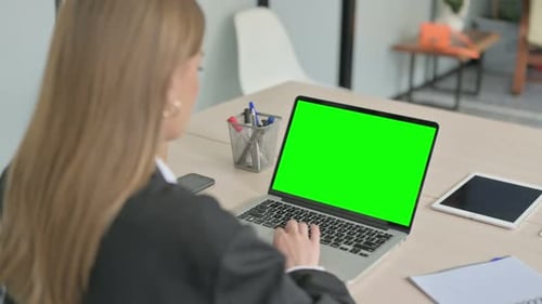 Young Businesswoman Using Laptop with Green Screen