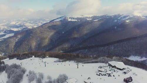 Old Ski Station on a Snowy Mountain Slope with a Lot of People on Skis and Snowboards