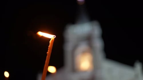 A candle is lit in front of a church
