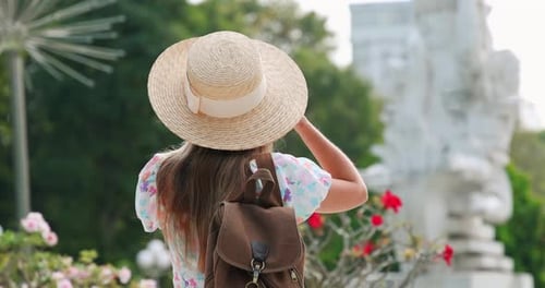 Viajante aproveitando as férias de verão fotografando esculturas em Vibrant