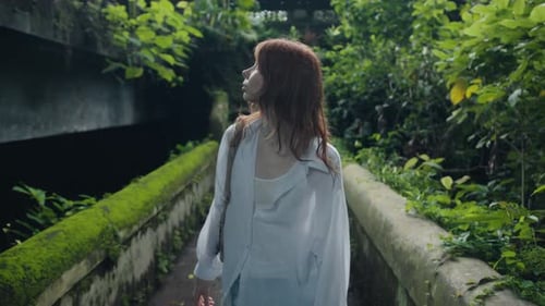 Young Woman Walking on the Old Bridge at Sunrise Traveling Alone