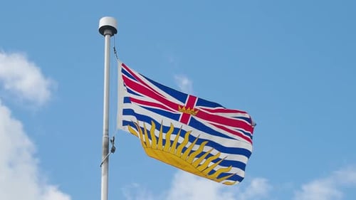 British Columbia Flag Waving Against Blue Sky