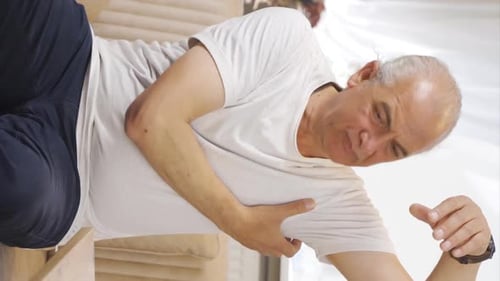 Vidéo verticale d'un vieil homme aux aisselles qui démangent. Problème de champignons.