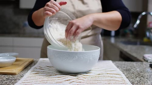 Adding White Flour to Ceramic Bowl from Another Bowl in a Cozy Kitchen