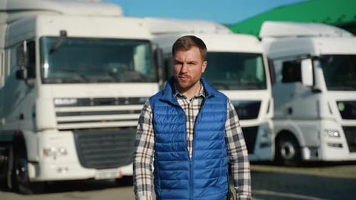 Truck Driver Walking Through Parking Lot on a Sunny Day
