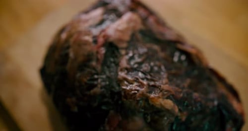 Close up view of raw beef steak on the table while adding salt with pepper and spices at fresh meat.
