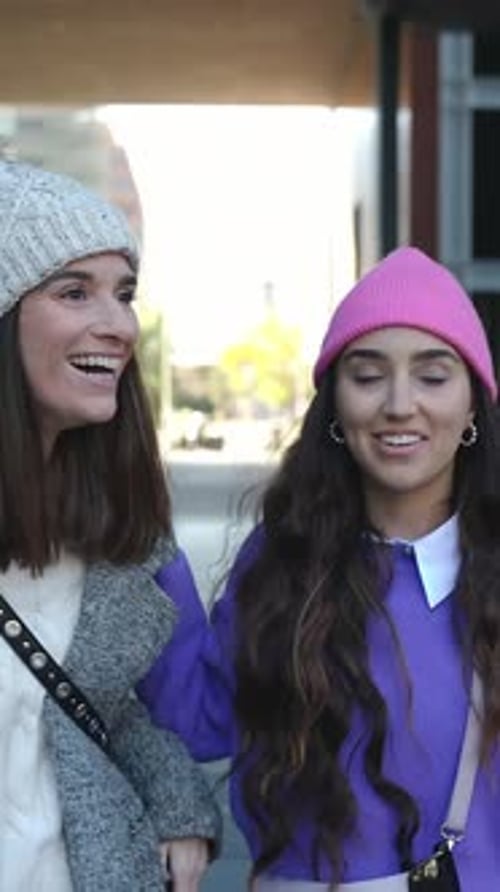 Two Young Happy Women Laughing and Having Fun Together Walking at City Street
