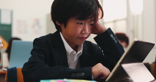 Boy, tablet and child stress in class, online and frustrated with digital quiz or assignment