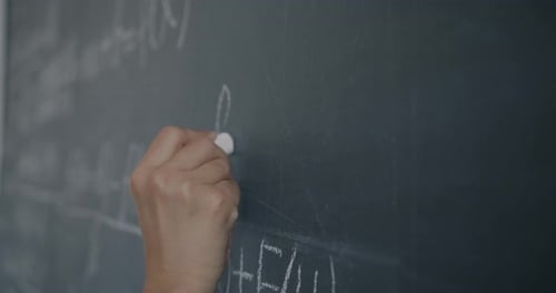 Closeup Slow Motion of Female Hand Writing Formula on Chalkboard While Woman Student Learning in