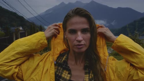 Beautiful Girl in a Yellow Raincoat Puts on a Hood A Woman in Enjoys the Rain Cold Foggy Autumn Day