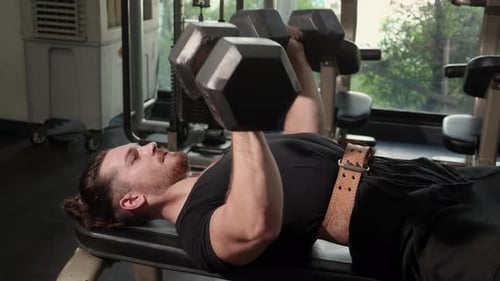 Junger kaukasischer Mann beim Training der Übung oder beim Training mit Hantelheben für Bodybuilder mit starken.