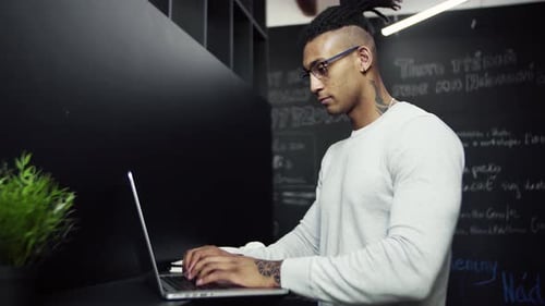 Young businessman working on laptop in modern office environment