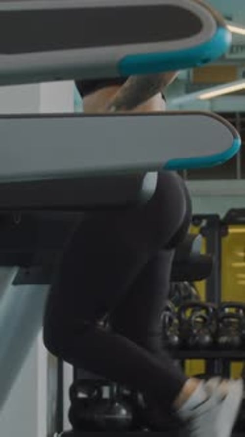 Vertical of Female Athlete Jogging on Treadmill at Gym