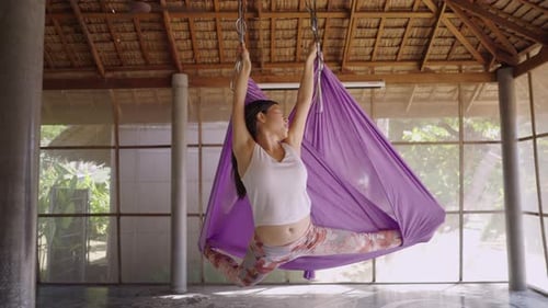 Groupe de femmes assises dans des sangles de yoga aériennes avec les jambes croisées