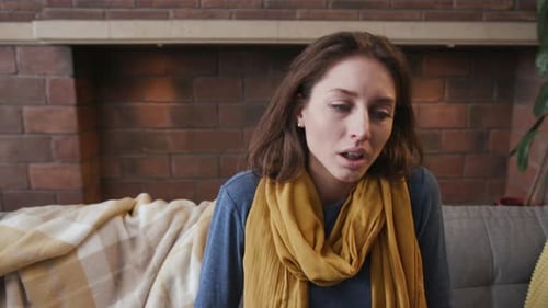 Woman Resting on Couch, Eyes Closed, Takes Deep Breaths