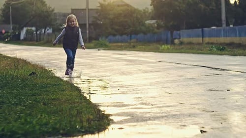Happy Child Girl Running and Puddles in the Rain in Summer