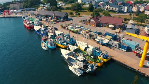 Drone flying over fishing boat moored in the marina in Jastarnia, Poland at sunny summer day