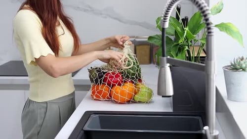 Woman Unpacking Fresh Vegetables and Fruits in Kitchen