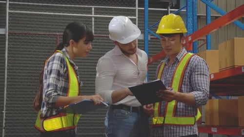 Group team engineer while manager talking with worker and looking document on clipboard at warehouse
